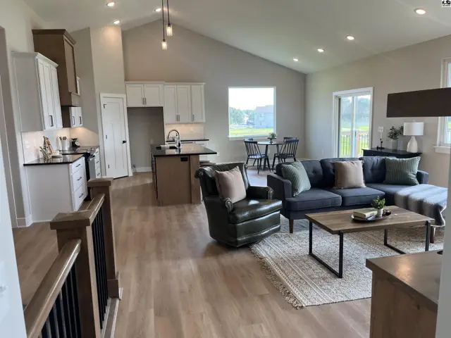 Spacious open-concept living area with vaulted ceilings, modern kitchen, and comfortable seating.