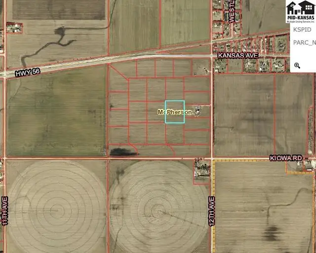 Aerial view of rural land parcels divided by red lines, with a highway and irrigation circles visible.
