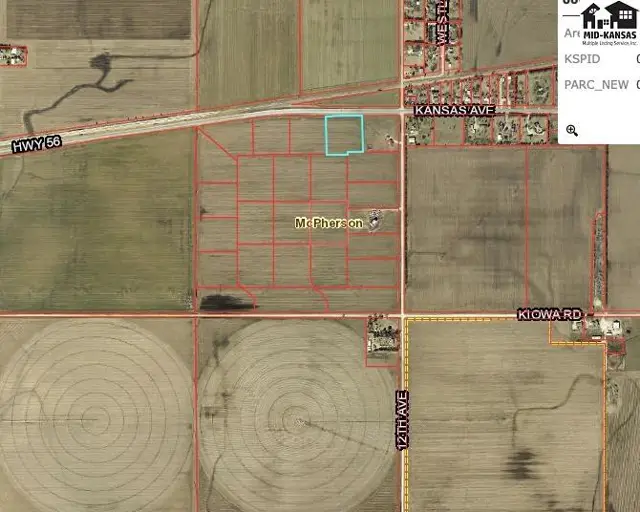 Aerial view of rural land parcels with irrigation circles and a small cluster of buildings.