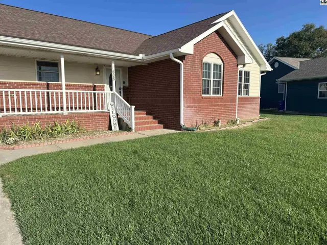 Brick and vinyl siding home with a covered porch and white railing.
