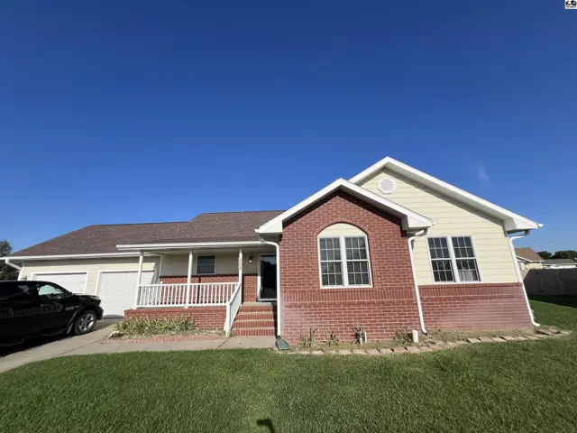 This single-story home features a brick and vinyl exterior with a covered front porch.