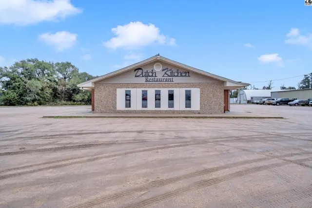Commercial building exterior with brick facade, beige siding, and "Dutch Kitchen Restaurant" signage.
