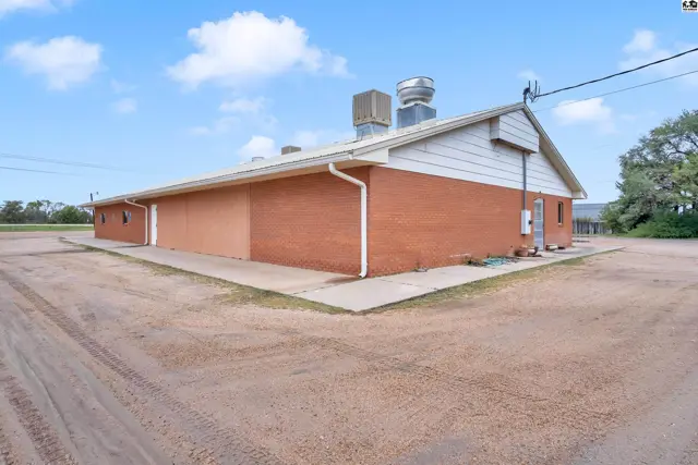 Commercial building with brick and stucco exterior, white trim, and rooftop ventilation.
