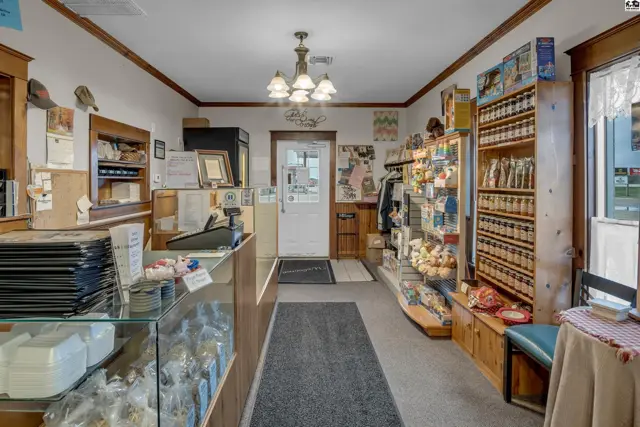 Interior view of a retail space with wooden shelves, glass display cases, and a checkout counter.