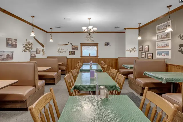 Diner interior with brown leather booths, green checkered tablecloths, and rustic wall decor.