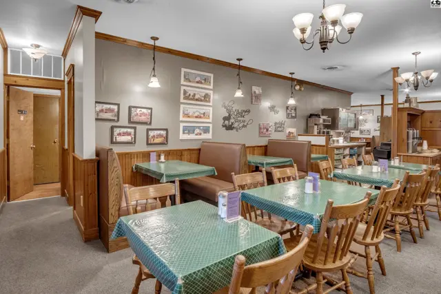 Cozy dining area with booth seating, wood paneling, and framed artwork.