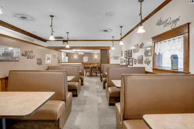 Cozy dining room with brown leather booths, light wood trim, and decorative wall art.