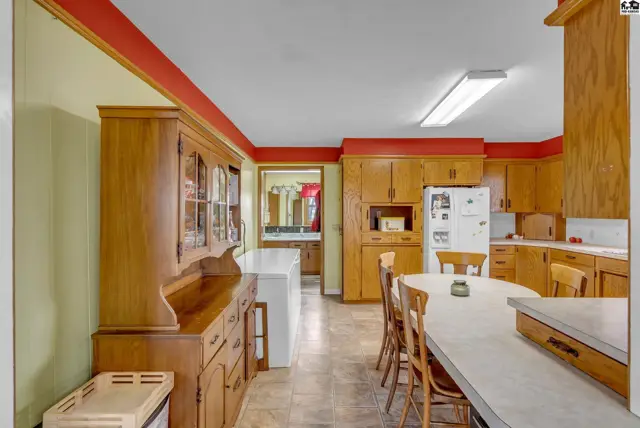 Spacious kitchen with light wood cabinets, a large hutch, and an oval dining table.