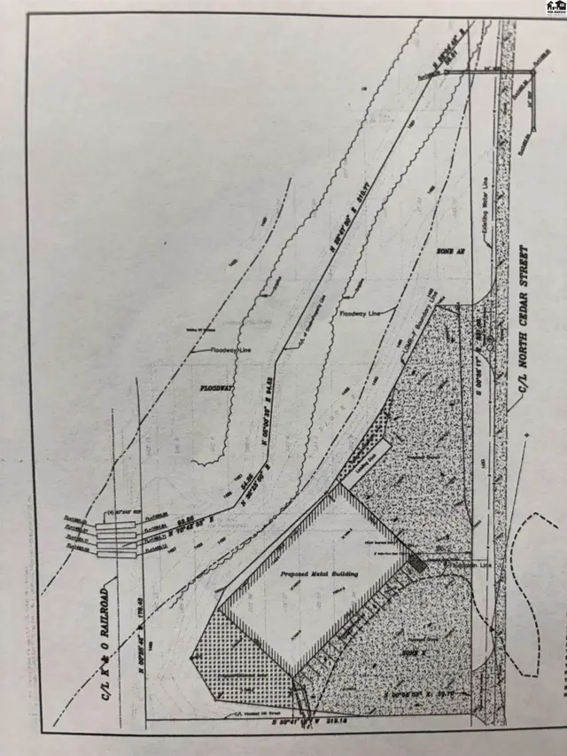 Architectural drawing shows a proposed building site with railroad tracks and a street.