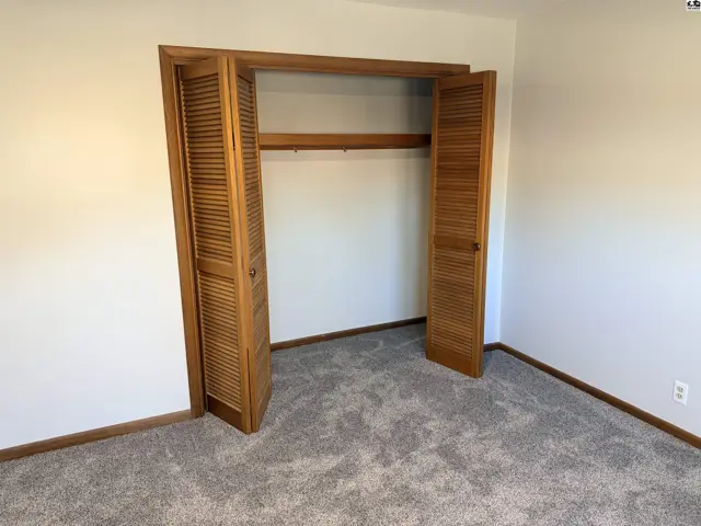 This room features a bi-fold louvered closet door with a wooden rod.