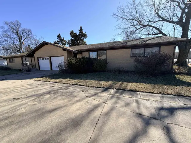 Brick ranch home with attached two-car garage and covered front porch.