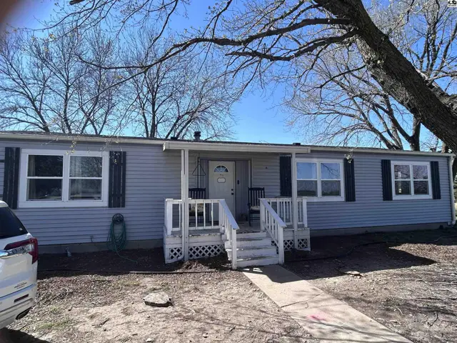 Light blue vinyl siding and white trim adorn this single-story home with a covered front porch.