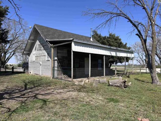 Rustic, weathered siding and a metal-roofed porch define this charming, single-story country home.