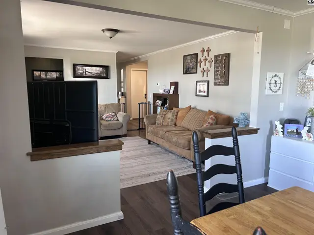 Spacious living room with neutral walls, wood floors, and comfortable seating.