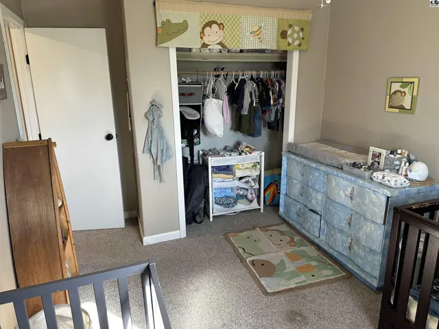 Nursery with cribs, changing table, and monkey-themed decor.