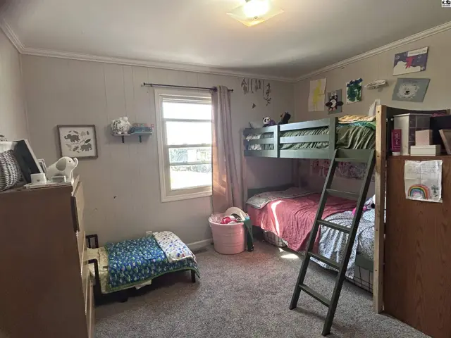 Children's bedroom with bunk beds, a twin bed, and a dresser, featuring gray carpet and neutral walls.