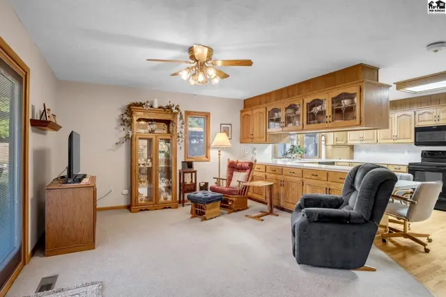 Spacious living area with plush carpet, wood cabinetry, and a cozy recliner.