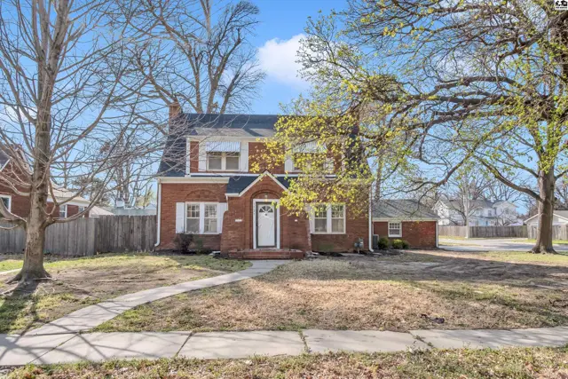 Charming brick two-story home with white-trimmed windows and a welcoming front entrance.