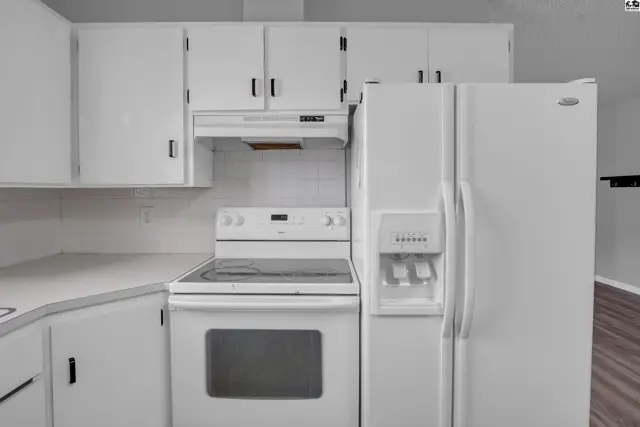White kitchen with white appliances, white cabinets, and white countertops.