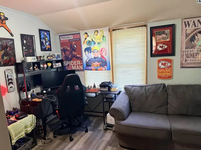 This room features a desk with a computer, a gaming chair, and a sofa.