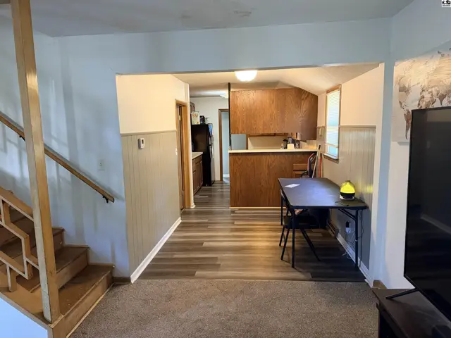 This home features a dining area adjacent to a kitchen with wood cabinets.