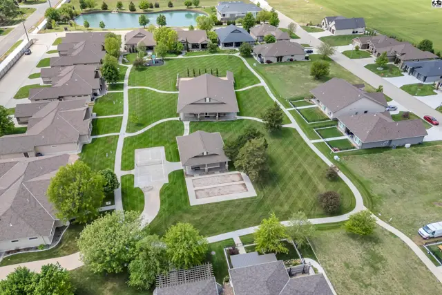 This aerial view shows multiple houses with manicured lawns and paved walkways.