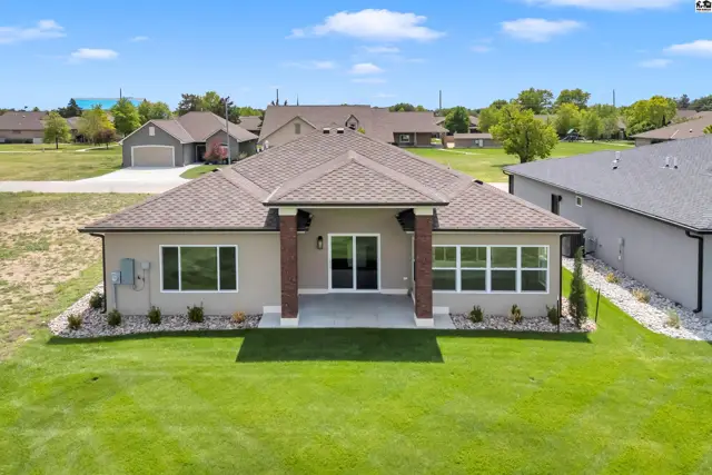 This modern home features a stucco exterior, large windows, and a covered patio.