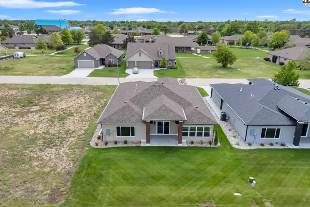 This modern home features a pitched roof, large windows, and a manicured lawn.