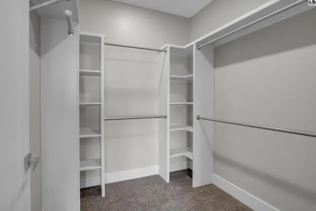 Spacious walk-in closet with ample shelving and hanging rods.