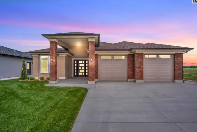 Modern home with brick accents, a covered entryway, and a three-car garage.
