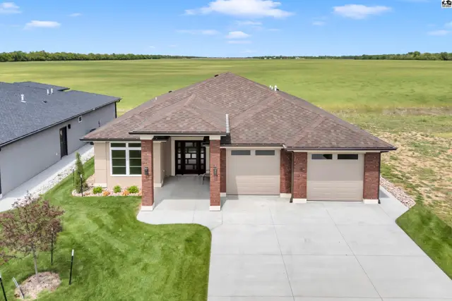 Modern home features a brick and stucco exterior with a three-car garage.
