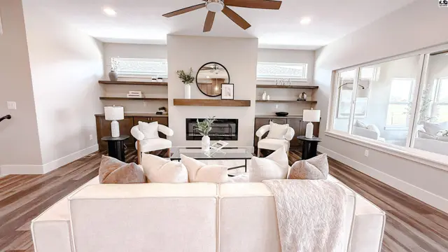 Spacious living room features a fireplace, built-in shelving, and large windows.