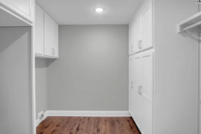 White cabinets line the walls of this room with wood-look flooring.