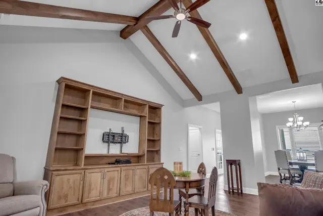 Vaulted ceiling with exposed wood beams above a built-in entertainment center.
