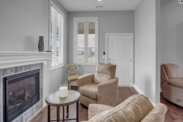 Living room features a fireplace, two upholstered chairs, and a round side table.