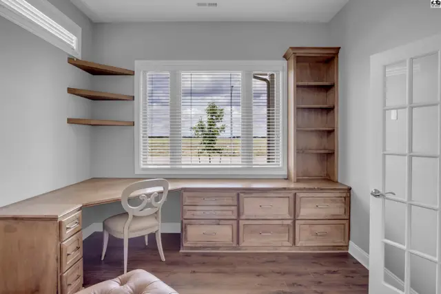 This room features a built-in desk, shelving, and a large window.