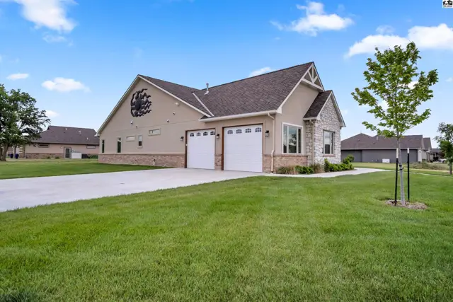 This modern home features a stucco exterior, stone accents, and a three-car garage.