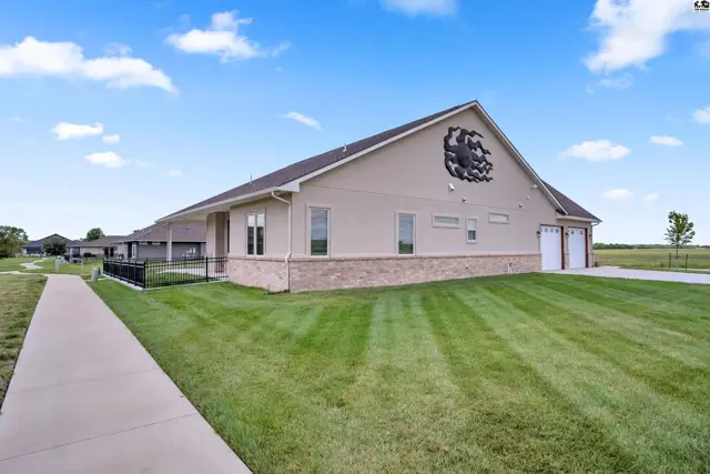 This tan stucco home features a brick accent base and a two-car garage.