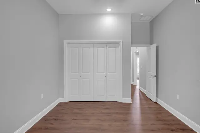 This room features a double door closet and wood-look flooring.