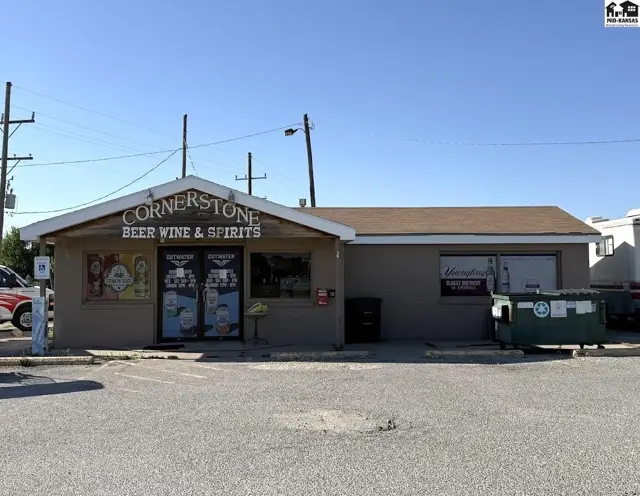 Commercial building exterior with "Cornerstone Beer Wine & Spirits" signage and a paved parking lot.