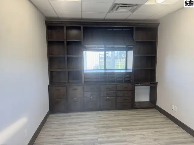 Spacious room with a large, dark wood built-in shelving and cabinet unit.