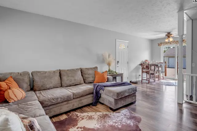 Spacious living room with a large sectional sofa, wood floors, and dining area visible.
