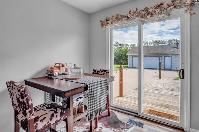 Dining nook with cow-print chairs and a sliding glass door opening to a deck and garage.