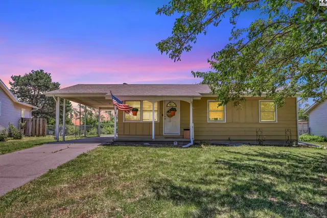 Charming single-story home with a covered carport, yellow siding, and a welcoming front porch.