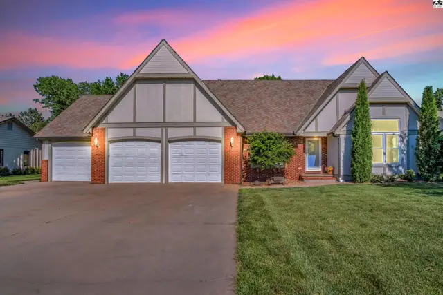 Spacious brick and siding home with a three-car garage and a welcoming blue front door.