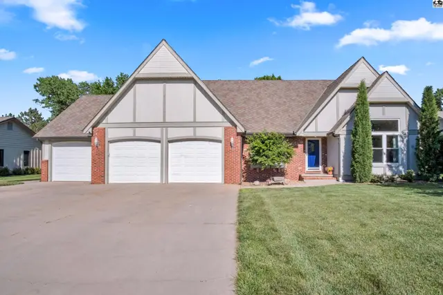 Spacious home with brick accents, white siding, a blue door, and a three-car garage.