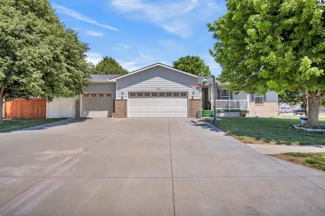 Spacious ranch home with a three-car garage, light gray siding, and brick accents.