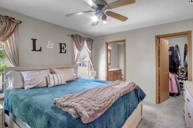 Spacious primary bedroom with a king-size bed, plush carpet, and a walk-in closet.