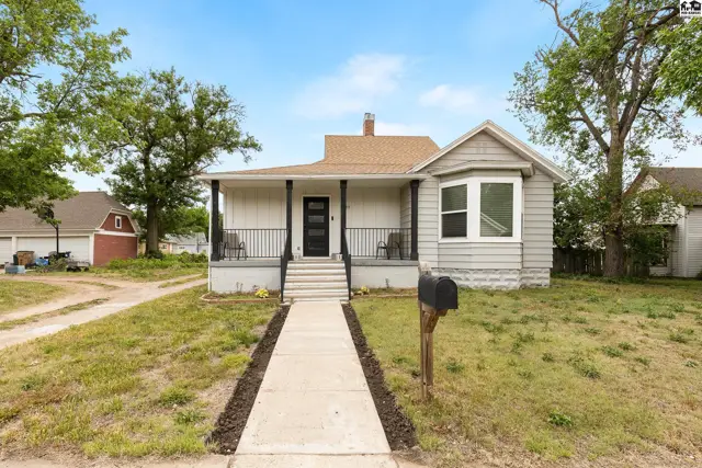 Charming bungalow with a covered front porch, bay window, and light gray siding.