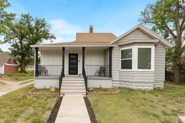 Charming light gray siding home with a covered porch, bay window, and a welcoming front entrance.